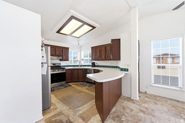 2491 Highway 89, Unit 614 Pleasant View, UT 84404 - Photo 9 of 27 Kitchen featuring brown cabinetry, white countertops, and a tiled backsplash