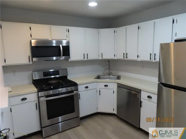 a kitchen with cabinets stainless steel appliances and a counter space