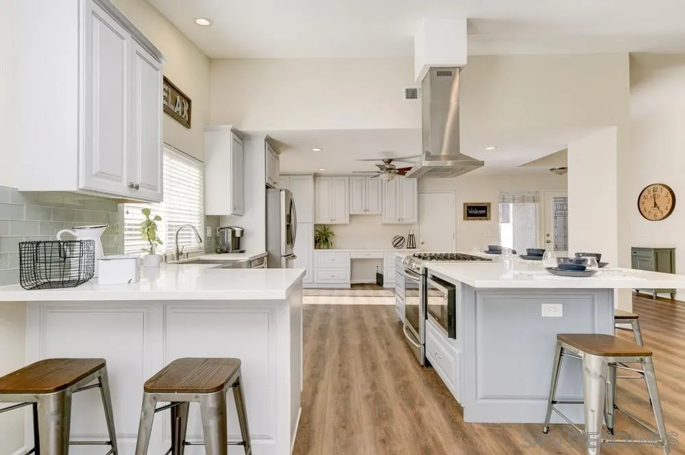 a kitchen with cabinets a sink and chairs