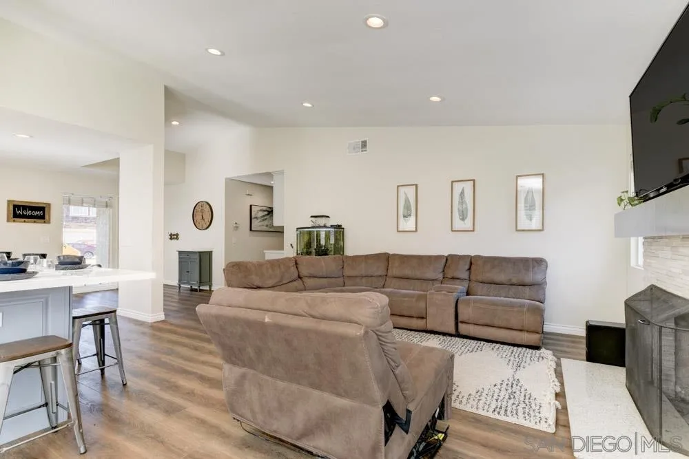9317 Lake Country Drive Santee, CA 92071 - Photo 14 of 32 a living room with furniture a flat screen tv and kitchen view