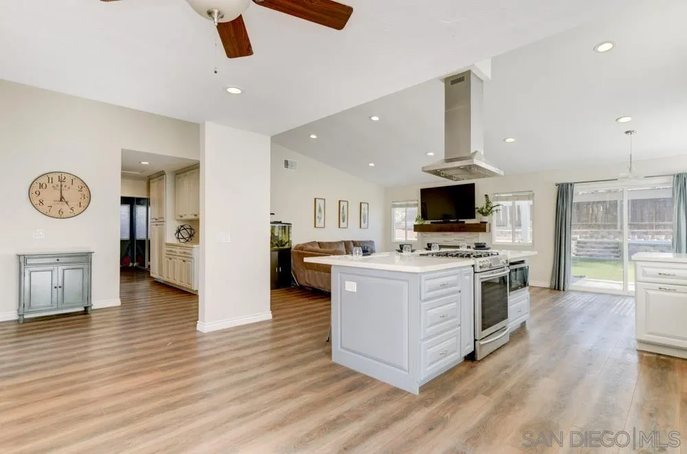 9317 Lake Country Drive Santee, CA 92071 - Photo 9 of 32 a kitchen with stainless steel appliances a stove top oven a sink dishwasher and a refrigerator with wooden floor