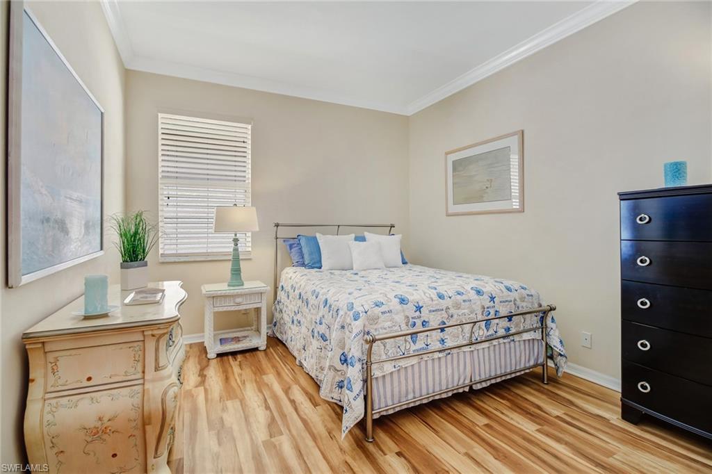 5706 Lago Villaggio Way Naples, FL 34104 - Photo 15 of 32 a bedroom with a bed and wooden floor