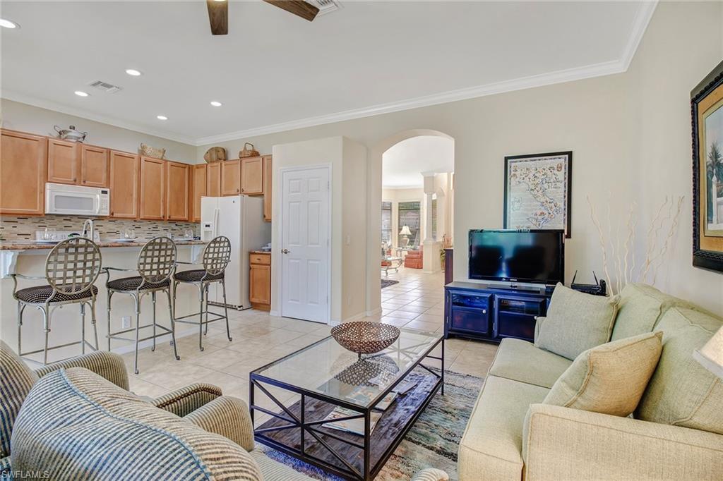 5706 Lago Villaggio Way Naples, FL 34104 - Photo 18 of 32 a living room with furniture and a flat screen tv