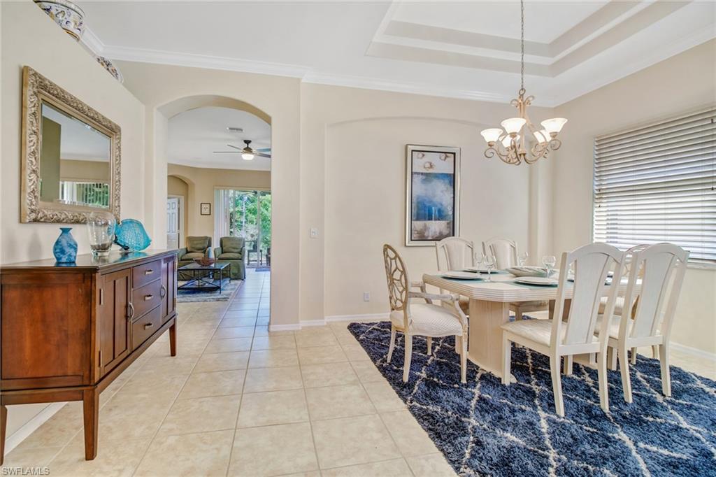 5706 Lago Villaggio Way Naples, FL 34104 - Photo 3 of 32 a view of a dining room with furniture and chandelier
