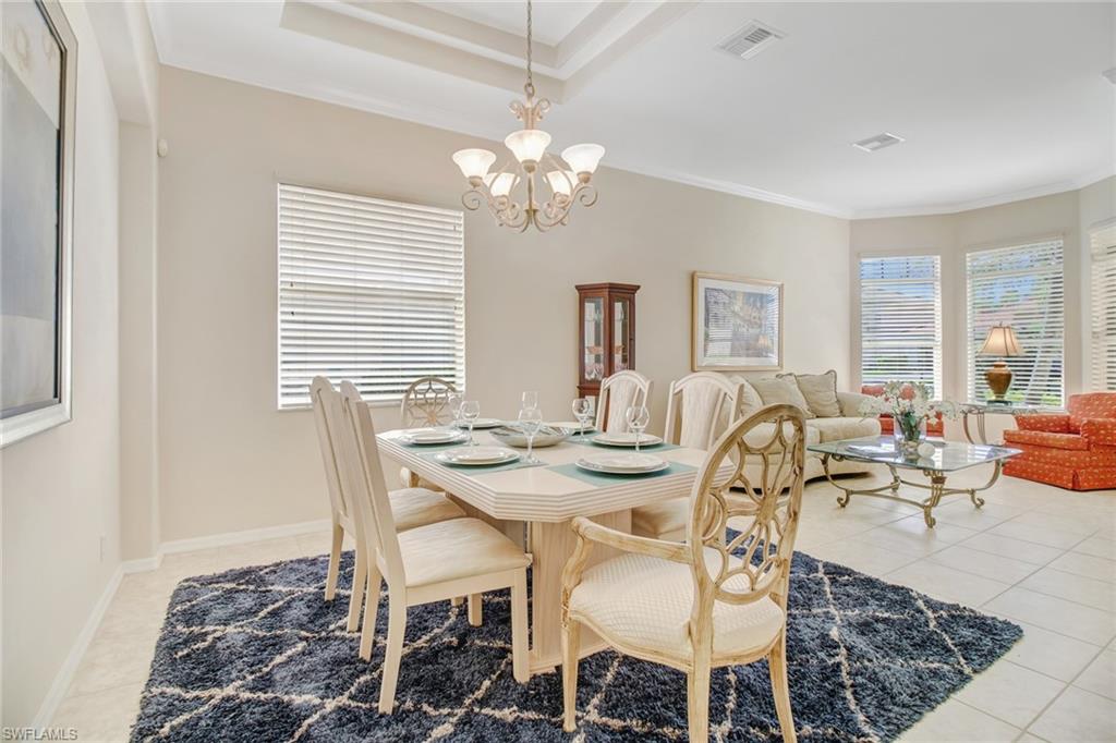 5706 Lago Villaggio Way Naples, FL 34104 - Photo 4 of 32 a view of a dining room with furniture a chandelier and wooden floor