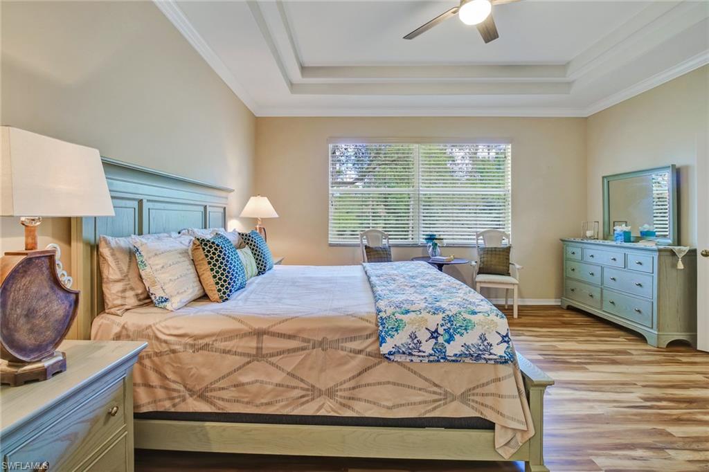 5706 Lago Villaggio Way Naples, FL 34104 - Photo 8 of 32 a bedroom with a bed and wooden floor