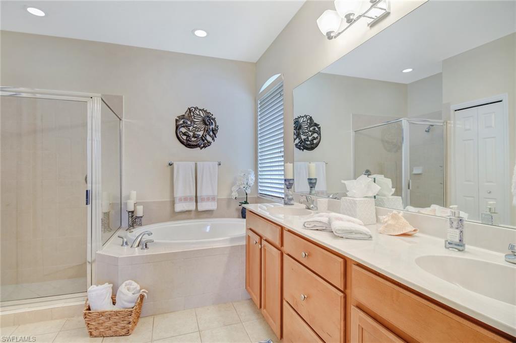5706 Lago Villaggio Way Naples, FL 34104 - Photo 9 of 32 a bathroom with a double vanity sink and a bathtub