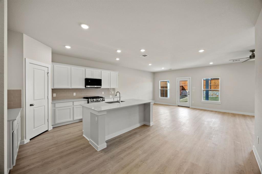 731 Carson Drive Forney, TX 75126 - Photo 2 of 31 a kitchen with stainless steel appliances a stove top oven a sink and a refrigerator