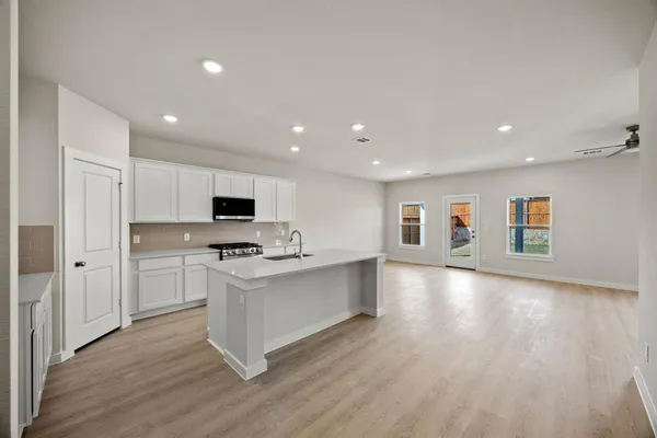 a kitchen with stainless steel appliances a stove top oven a sink and a refrigerator