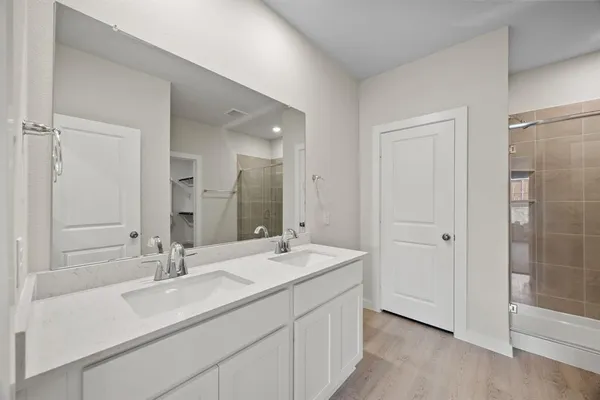 a bathroom with a double vanity sink mirror and shower