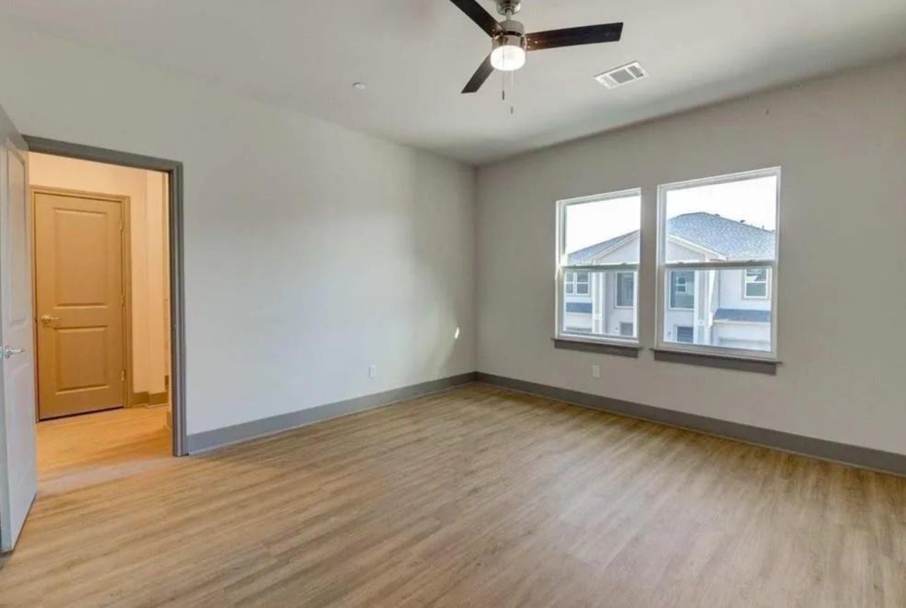 18620 Louetta Creek Drive, Unit 13A Spring, TX 77388 - Photo 13 of 15 an empty room with wooden floor cabinet and windows