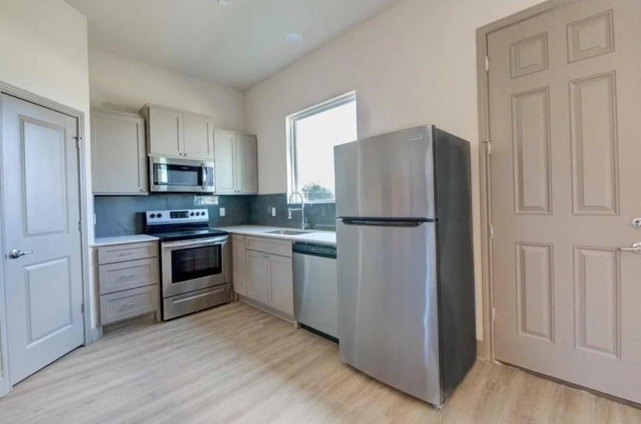 18620 Louetta Creek Drive, Unit 13A Spring, TX 77388 - Photo 8 of 15 a kitchen with white cabinets and stainless steel appliances
