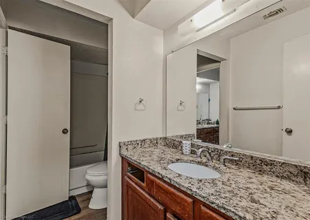 a bathroom with a granite countertop sink and a mirror