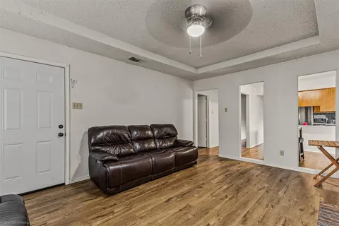 a living room with furniture and a wooden floor