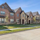 a view of a big house with a big yard and large trees
