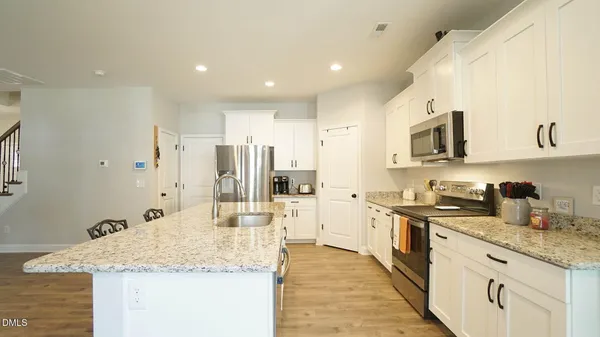 a kitchen with stainless steel appliances granite countertop a sink stove and refrigerator