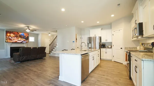 a kitchen with stainless steel appliances kitchen island granite countertop a stove and a refrigerator