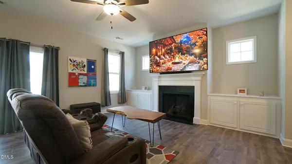 a living room with furniture a flat screen tv and a fireplace