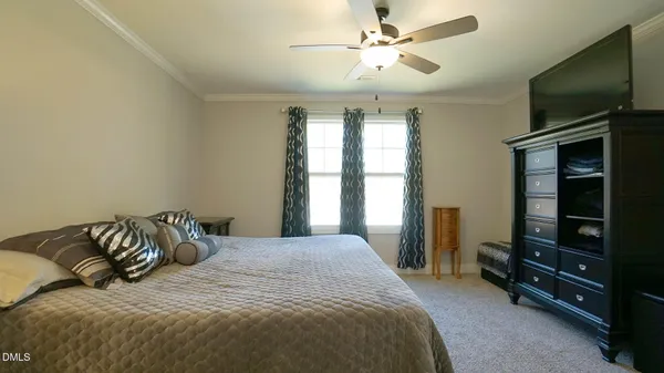 a bedroom with a bed and a flat tv screen on the dresser