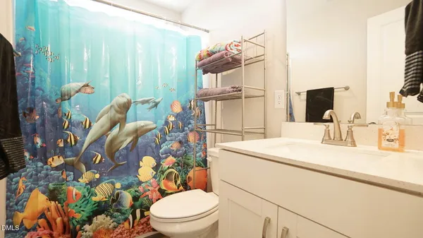a bathroom with a sink a toilet and shower curtain