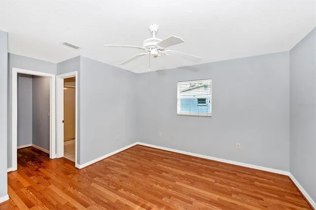 a view of a room with wooden floor and a ceiling fan