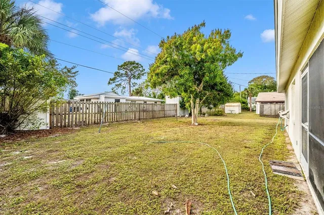a backyard of a house with table and chairs