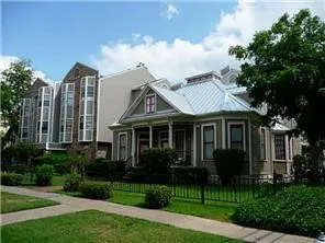 a view of a white house next to a yard with plants and trees