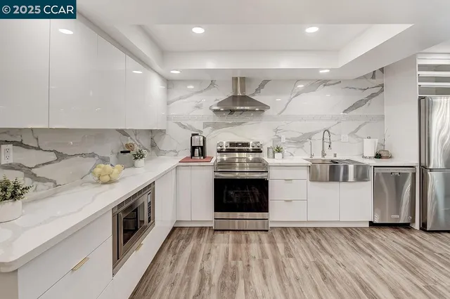 a kitchen with a sink stainless steel appliances and white cabinets