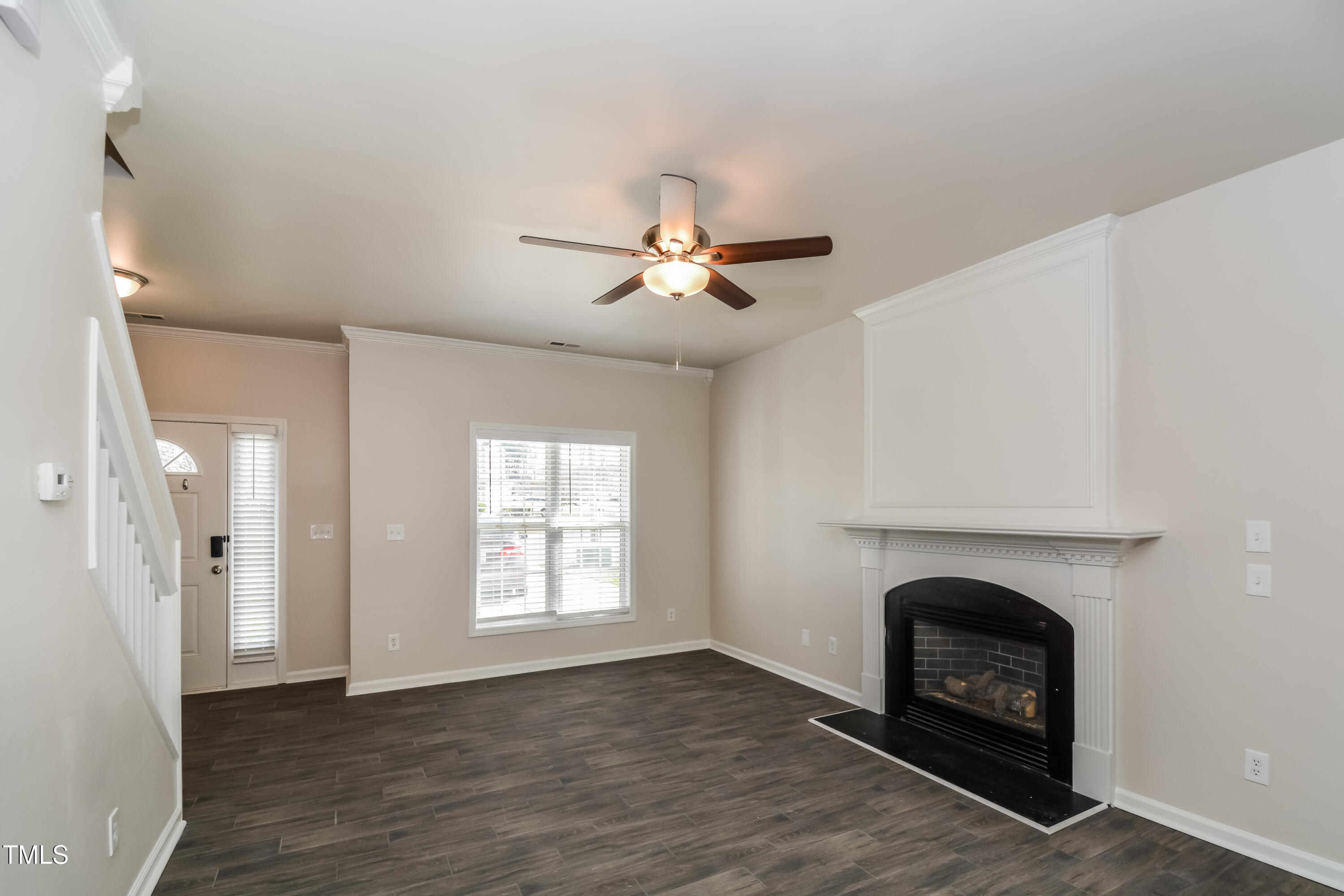 745 Southgate Drive Raleigh, NC 27610 - Photo 2 of 17 a view of a livingroom with a fireplace a ceiling fan and wooden floor