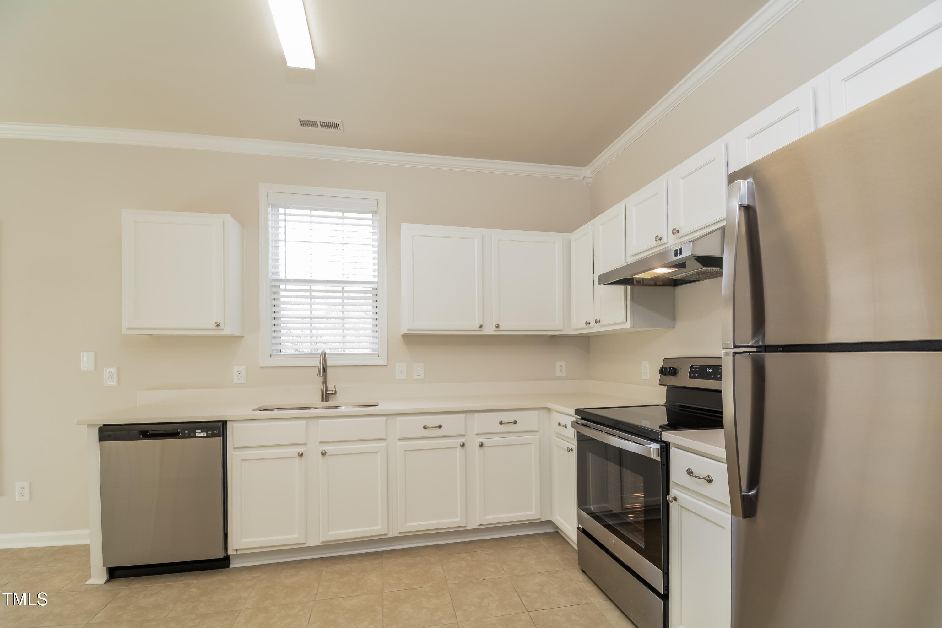 745 Southgate Drive Raleigh, NC 27610 - Photo 3 of 17 a kitchen with white cabinets and white appliances