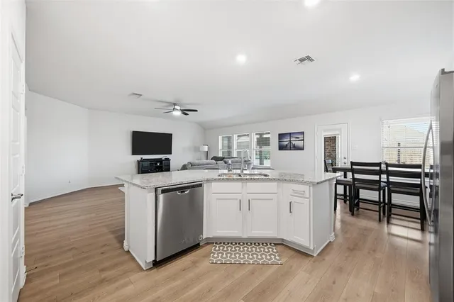 a kitchen with kitchen island a dining table and chairs