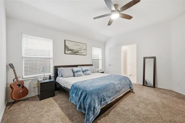 a spacious bedroom with a bed and a flat screen tv