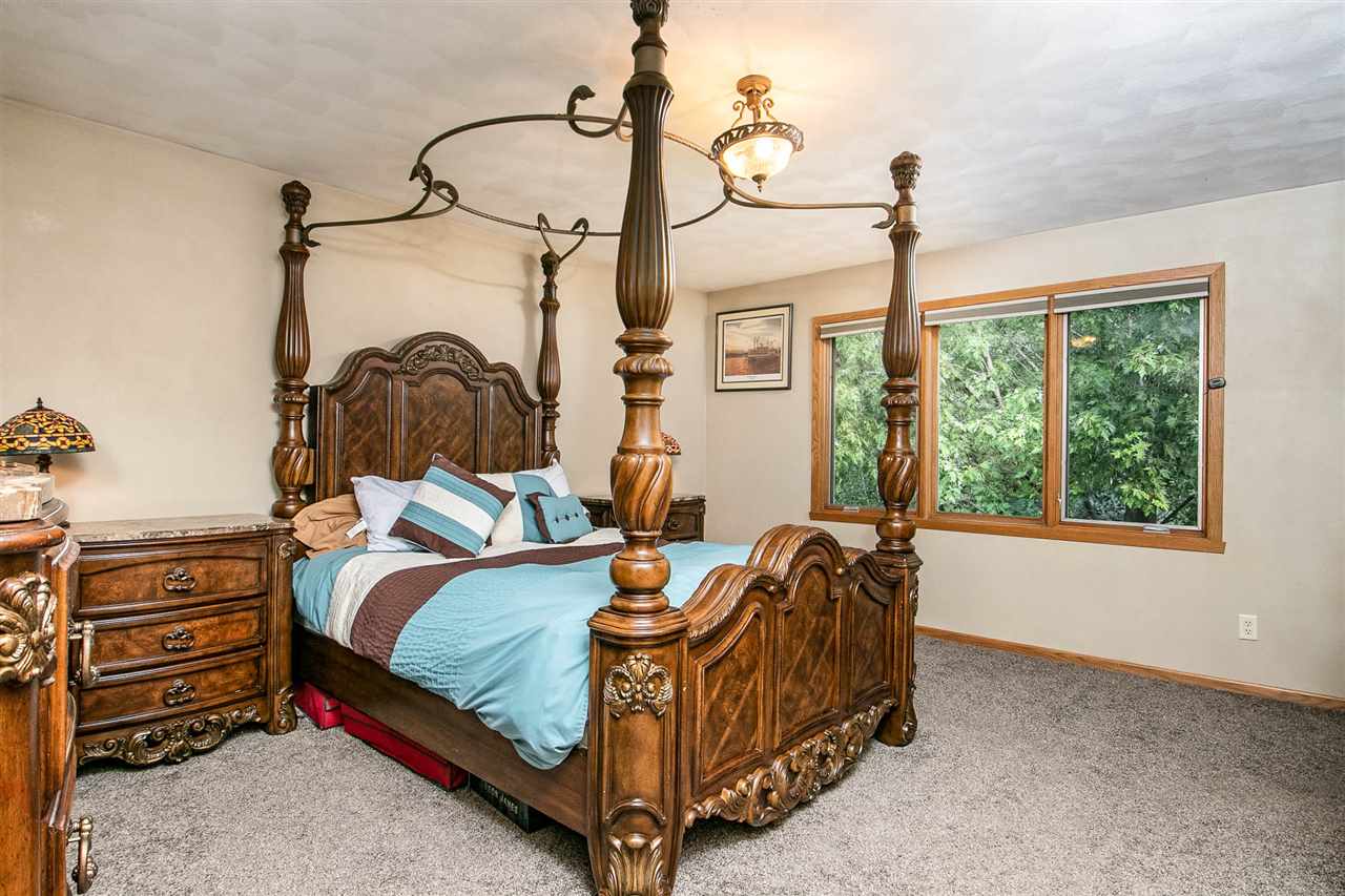 6820 Stone Cottage Road Rockford, IL 61114 - Photo 13 of 24 a bedroom with a bed a dresser next to a window