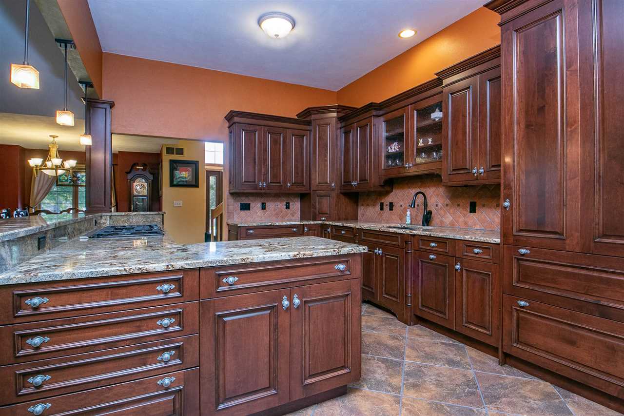 6820 Stone Cottage Road Rockford, IL 61114 - Photo 5 of 24 a kitchen with granite countertop wooden cabinets and a sink