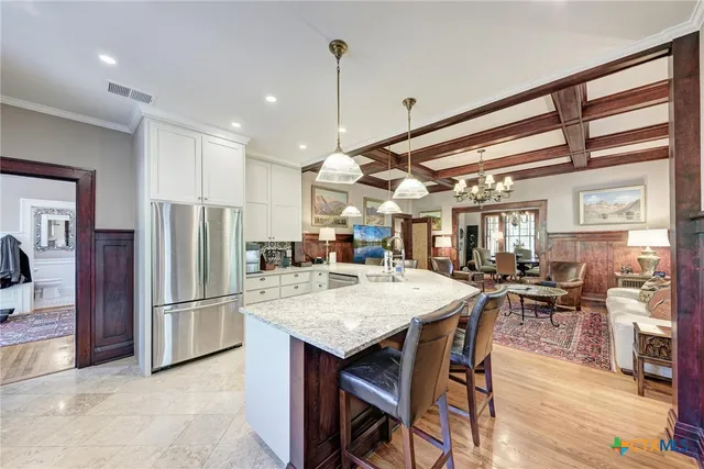 a kitchen with stainless steel appliances granite countertop a refrigerator and a table