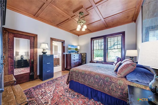 a bedroom with bed and wooden floor