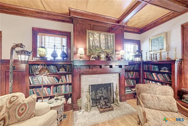 a living room with fireplace furniture and a book shelf