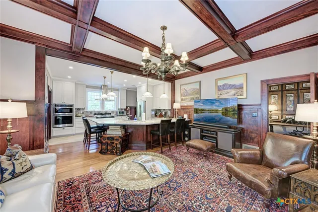 a kitchen with stainless steel appliances kitchen island granite countertop a table chairs and a chandelier