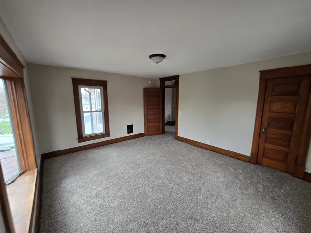 an empty room with windows and closet