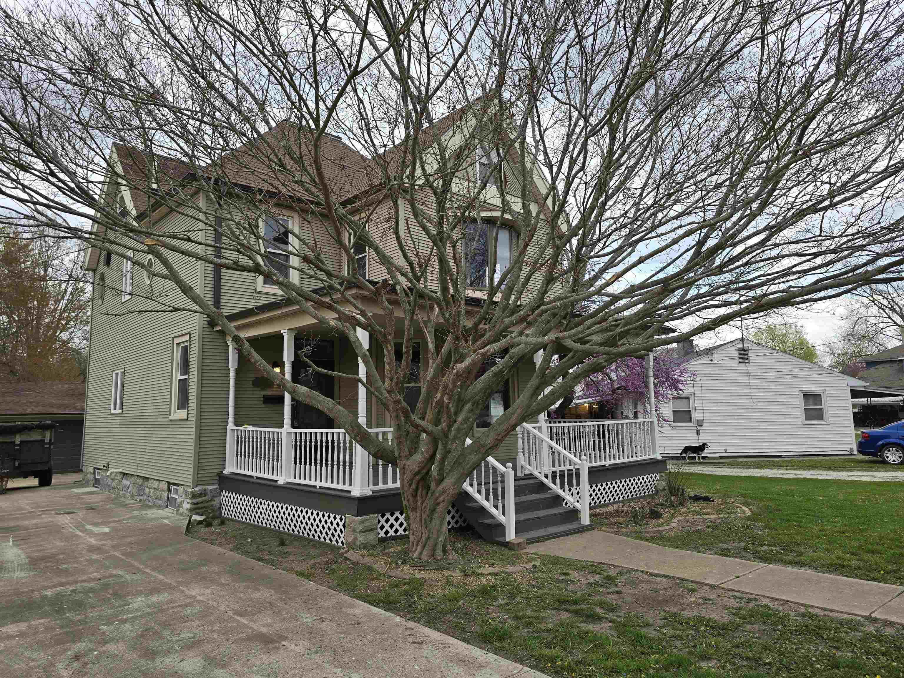 245 Cherry Street Carthage, IL 62321 - Photo 2 of 29 a view of a house with a large tree and a yard