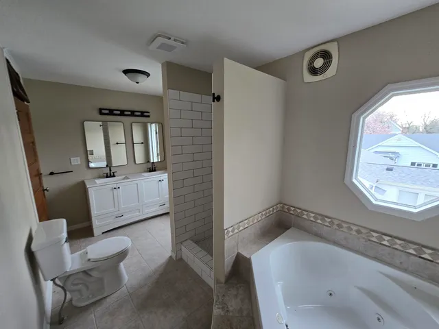 a bathroom with a tub sink and mirror