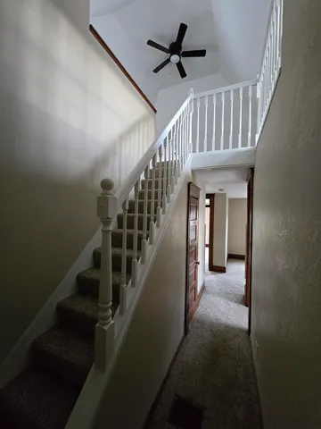 a view of staircase with railing and white walls