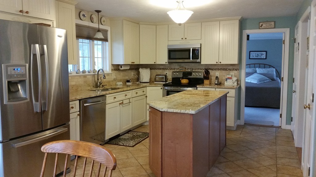 5 Bog Iron Road Wareham, MA 02576 - Photo 8 of 21 a kitchen with stainless steel appliances granite countertop a refrigerator a stove a sink a microwave and chairs