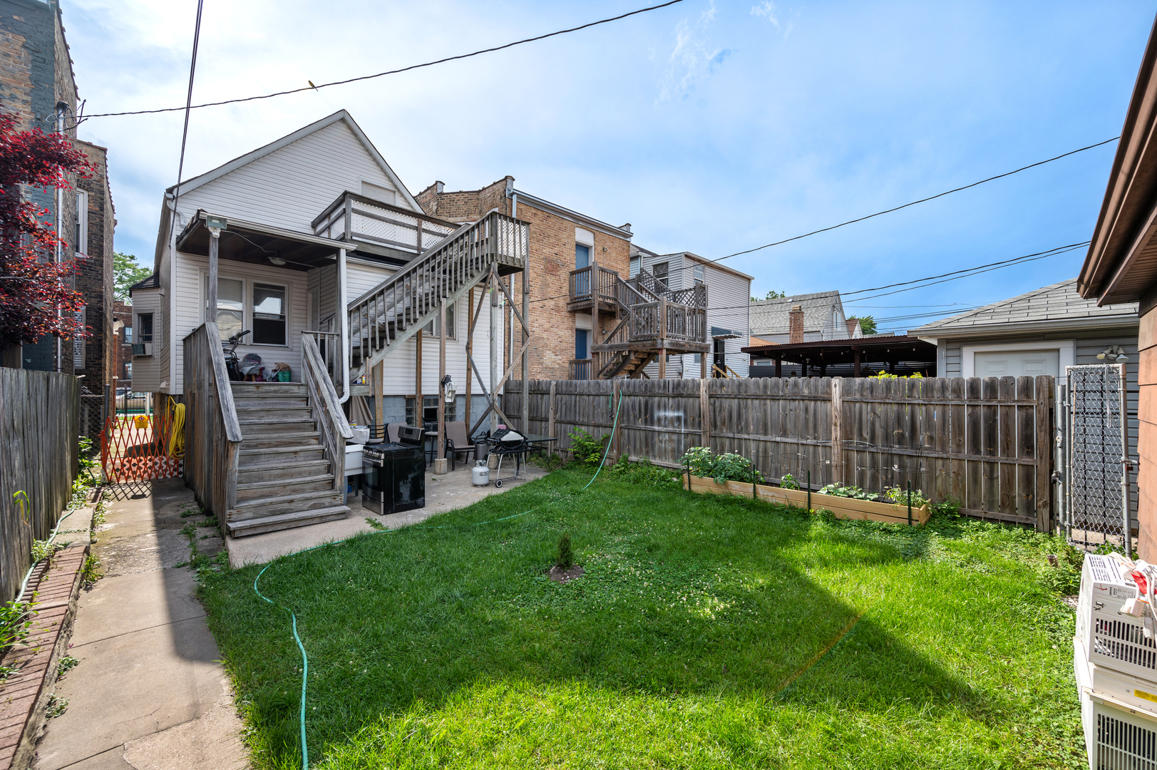 2109 North Karlov Avenue Chicago, IL 60639 - Photo 20 of 22 a view of a house with a small yard and wooden fence