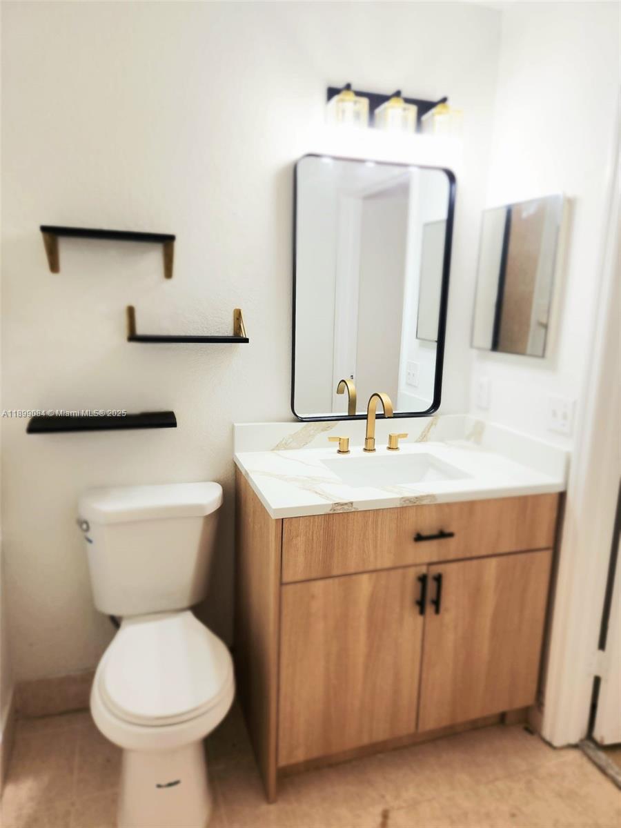 18861 Northwest 86th Court, Unit 3903 Hialeah, FL 33015 - Photo 5 of 14 a bathroom with a toilet sink and mirror
