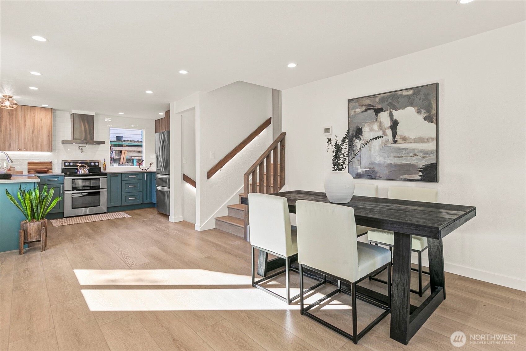 a living room with furniture and kitchen view with wooden floor