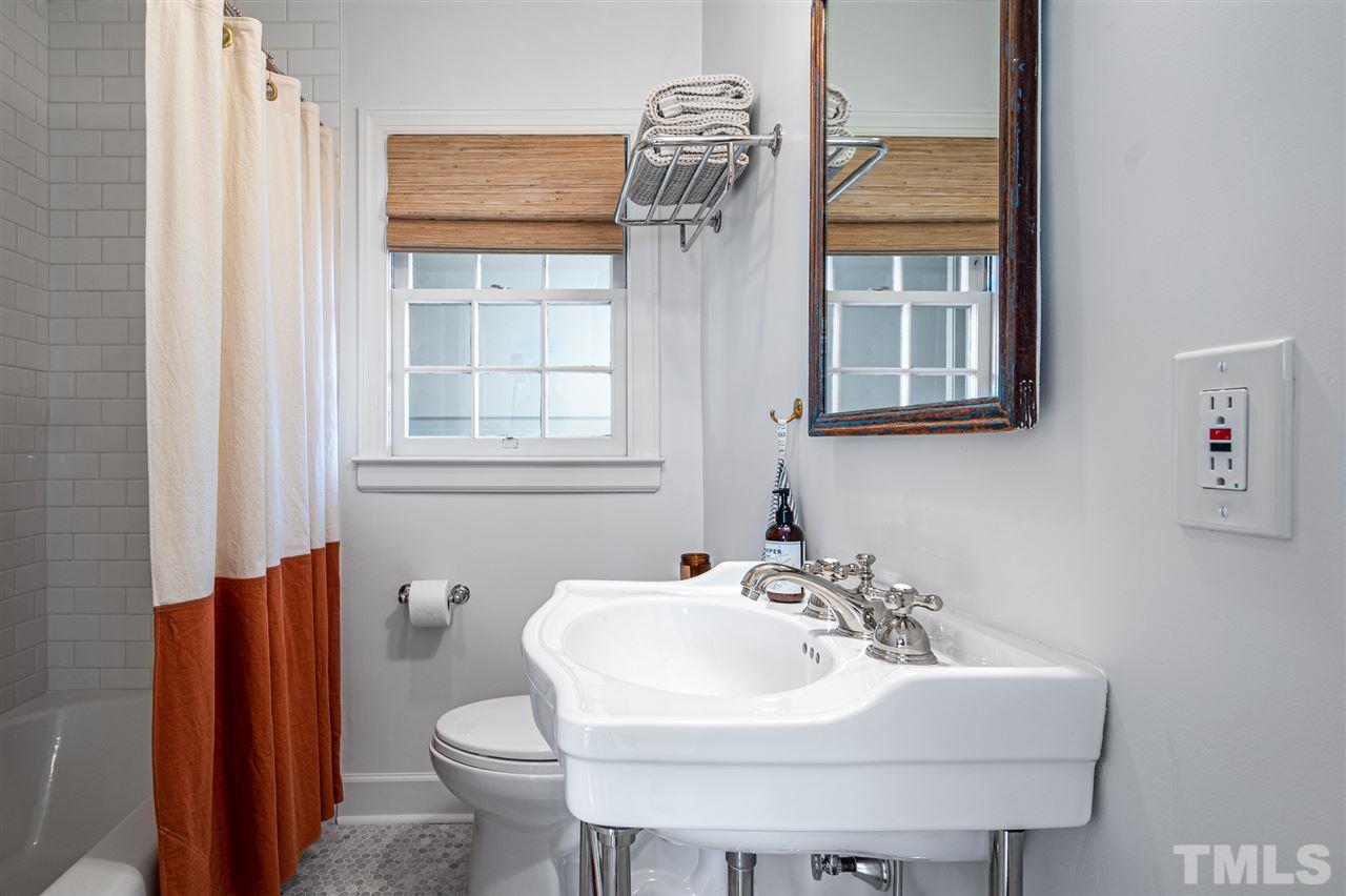 311 Dacian Avenue Durham, NC 27701 - Photo 19 of 30 a bathroom with a sink a toilet and a mirror