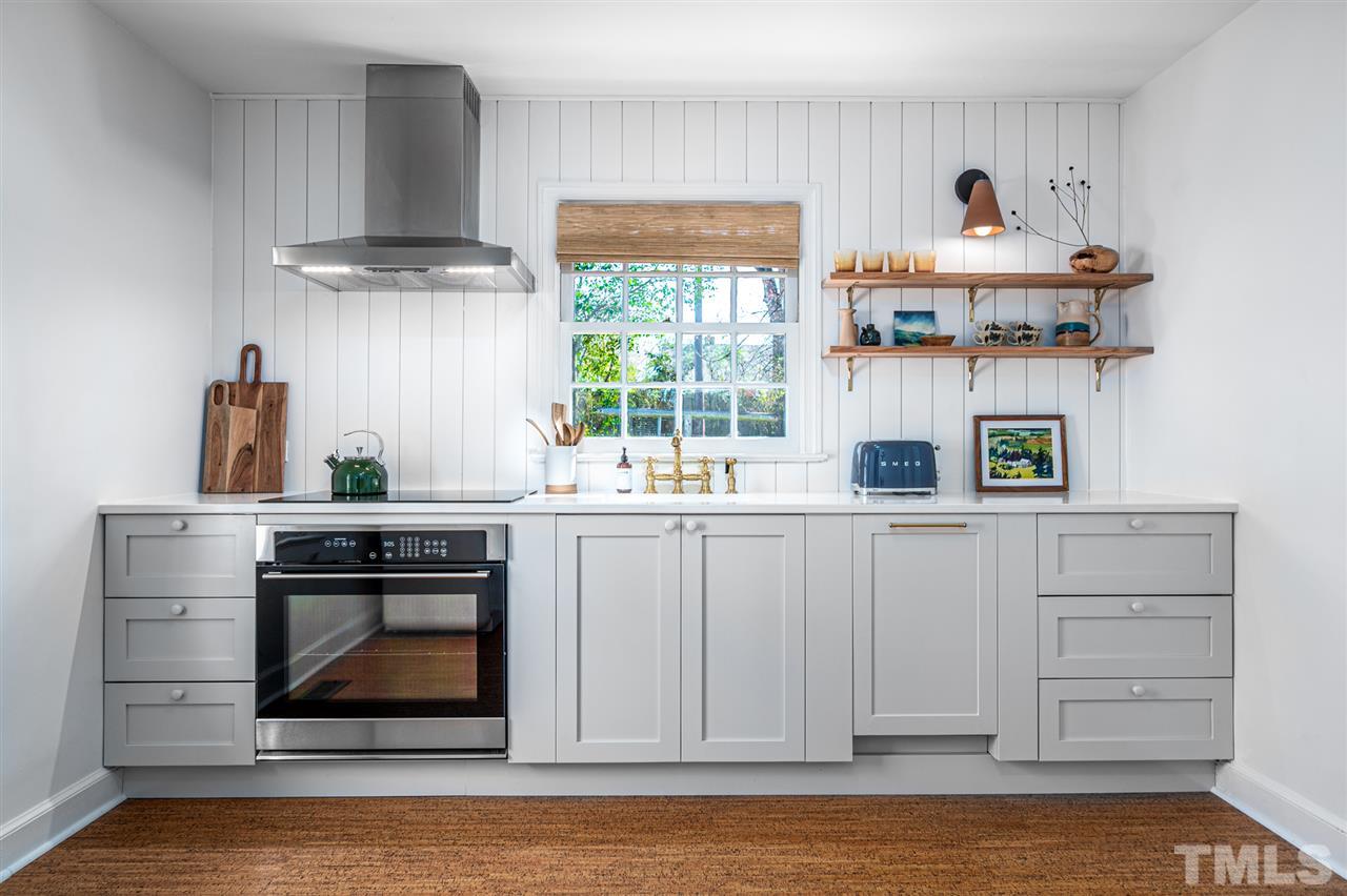 311 Dacian Avenue Durham, NC 27701 - Photo 8 of 30 a kitchen with stainless steel appliances a stove and white cabinets