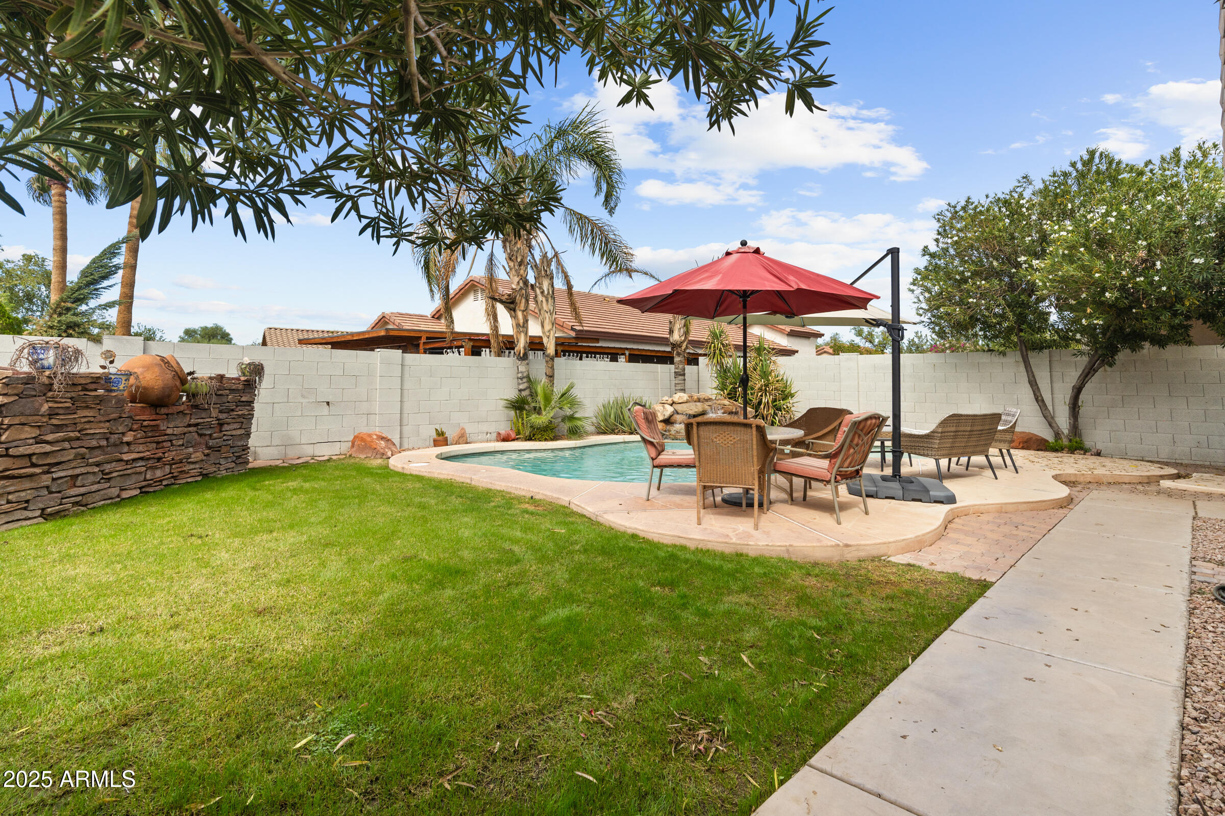1140 South Rockwell Street Gilbert, AZ 85296 - Photo 25 of 29 a view of a backyard with table and chairs under an umbrella