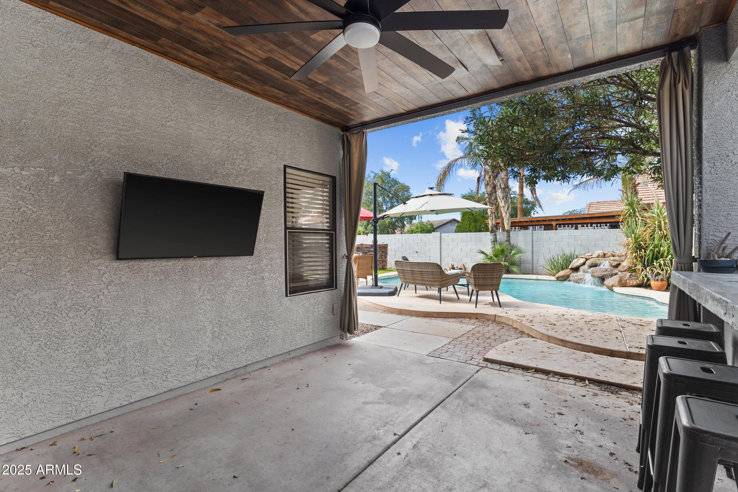 1140 South Rockwell Street Gilbert, AZ 85296 - Photo 29 of 29 a living room with patio furniture and a flat screen tv